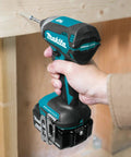 Person using the 18V LXT Brushless Cordless Drill And Impact Driver Combo Kit With 5.0Ah Batteries on wooden surface.