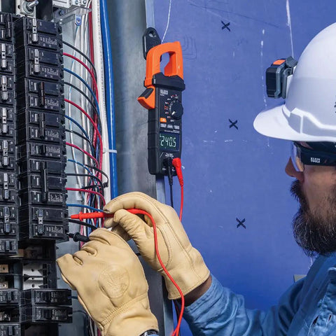 Electrician using Digital Clamp Meter With True RMS And LoZ Auto Ranging for AC/DC voltage check on electrical panel