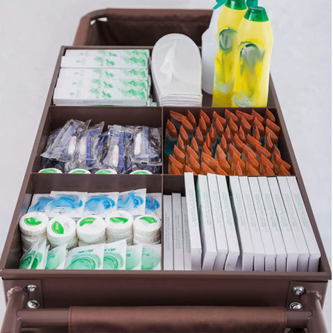 Straight Up Heavy Duty Three Tier Cleaning Cart With Two Roomy Cabinets And Smooth Rolling Wheels For Hotel Housekeeping Hustle Sturdy Painted Iron Frame Top Shelf Lid And Nifty Side Pocket Storage In Brown filled with cleaning supplies and toiletries.