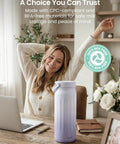 Slick Portable Breast Milk Cooler Bag Holding Two 22oz Feeding Bottles With A Heavy Duty Stainless Steel Frost Core That Keeps Formula Fresh For Over Twenty Four Hours No Ice Needed Hella Convenient For Busy Moms On The Road Or Weekend Getaways with a purple canister near a woman working on a laptop.