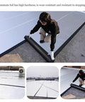 Woman applying Tough As Nails Bitumen Waterproof Tape With Sturdy Aluminum Foil Backing for rooftop sealing.