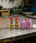Ultimate 10 Piece Tig Gas Lens Kit For Wp 17 18 And 26 Welding Torch showing copper collets and purple nozzles on a workbench.