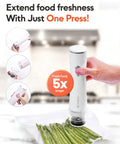 Compact Handheld Vacuum Sealer Kit With 30 Reusable Bags, cordless sealer in use with plastic asparagus bag on kitchen counter.