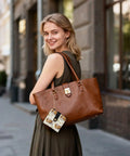 Smiling woman holding a brown handbag with a Totally Clutch Vintage Rickshaw Bifold Wallet For Women Featuring Autumn Leaves Motif.