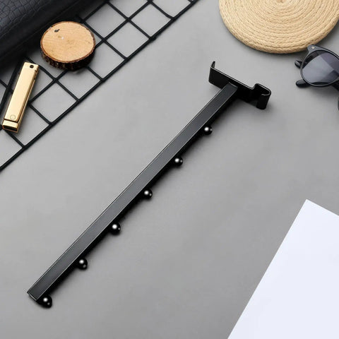 Six-Pack Gridwall Hooks in Matte Black, Waterfall 6-Ball Design on gray surface