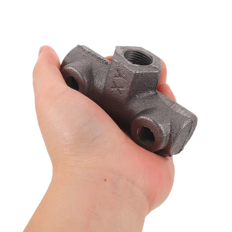 Hand holding Beefy Cast Iron Pneumatic Air Switch Mount Four Way Fitting With One Half Inch And One Quarter Inch Female Threads