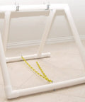 Adjustable Teeter Base For Dog Agility Training From Flat To AKC Height in white PVC on a tile floor