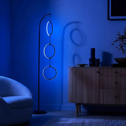 Dope RGB Color Changing Floor Lamp With Arching Three-Ring Pendant in modern living room, dimmable LED, black sleek finish, ambient blue glow.