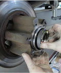 Hand installing hub nut using Ford 4 Lug Rear Axle Nut Socket Wrench For F Series Trucks Ten And A Half Inch Spindle Nut Size Two And Three Quarter Inch Outer Heavy Duty Hub Nut Tool For Quick DIY Removal And Installation On F 250 And F 350 Models