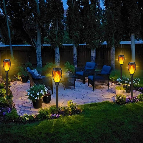 8 Pack Solar Tiki Torch Lights With Realistic Flickering Flame For Outdoor Garden Decor Waterproof LED Pathway And Patio Yard Lights That Charge In Sun Weatherproof And Easy To Install illuminating a patio at night