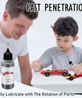 Father and son using 0.5 Oz Graphite Powder Lubricant for Pinewood Derby Cars Dry Lube on car wheels to reduce friction.