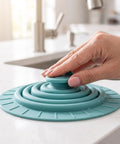 Bekecidi Bathtub Drain Cover, 6-Inch Silicone Tub Stopper, 3 Pack on kitchen countertop with a hand pressing down.