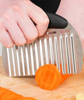 Close-up of a heavy-duty stainless steel crinkle cutter with an ergonomic black handle slicing a carrot.