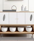Wooden sideboard with four white doors, modern design, decorative ceramic bowls below