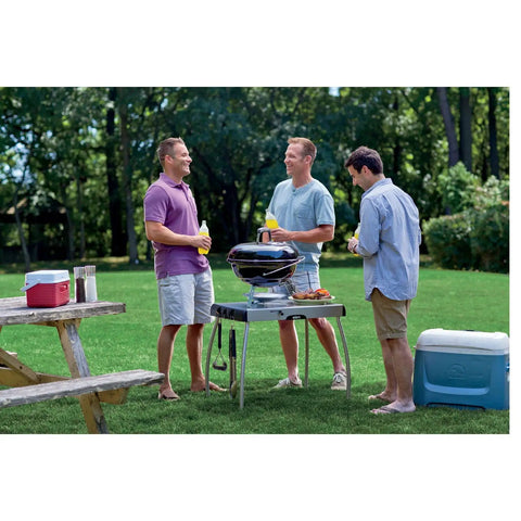 Three men enjoying outdoor gathering with Jumbo Joe Charcoal Grill 18 Inch Portable Kettle Bbq on a summer day.