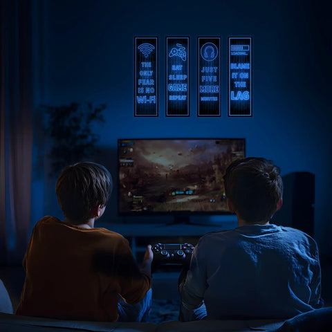 Two boys playing video games with Glow In The Dark Gamer Wall Decals Four Piece Set Featuring Joystick Controller Stickers above TV screen.
