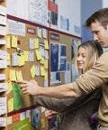 Couple pinning notes on a bulletin board with Total Game Changer 1000 Piece Assorted Color Map Push Pins For Travel World Map Markers And Wall Decoration Compact Size Thumbtacks With Slick Storage Box Always Ready To Flag Your Next Big Adventure.