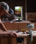 Man working with Two In One Universal Rotate 360 Degree Clamp On Vise With Drill And Grinder Holder in a woodworking shop.