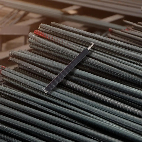 Housoutil 2Pcs Steel Rebar Wire Twisting Hook for Concrete and Fence Work on stacked steel rebar in a construction setting.