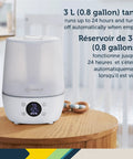 White filter free humidifier with auto humidity control and hygrometer on wooden table, digital display showing humidity level.