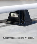 Side view of black rooftop pipe saddle support with base plate; pipe resting on top; Miro label visible