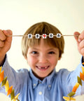 Child holding necklace with 100 Pcs Mahjong Beads For Jewelry Making With Pre Drilled Holes Charms Miniature Tile Spacers For DIY.