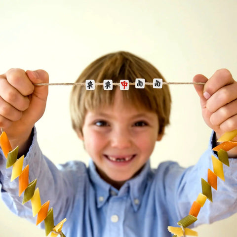 Child holding necklace with 100 Pcs Mahjong Beads For Jewelry Making With Pre Drilled Holes Charms Miniature Tile Spacers For DIY.