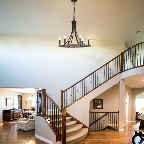 Wagon Wheel Farmhouse Chandelier With Six Lights hanging in a foyer, featuring black round design and rustic wood grain finish.