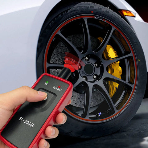 No Fuss Tpms Reset Tool For Universal Vehicle Tire Pressure Sensor Activation And OBD2 Programming in hand near tire.