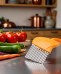 Orange vegetable crinkle cutter with stainless steel ribbed blade on kitchen counter