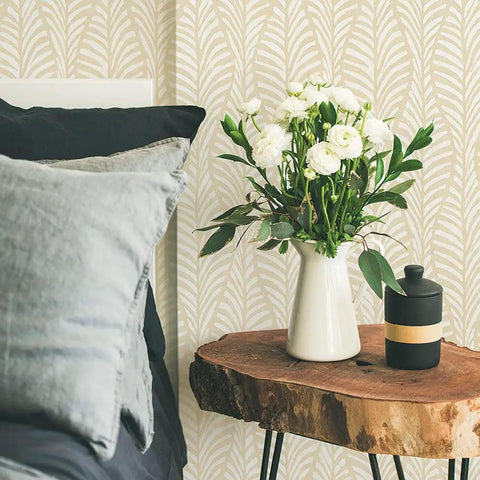 Removable Peel And Stick Wallpaper With Beige Block Print Leaves On Off White in bedroom, boho style with wooden table and flowers.