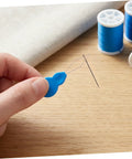 Gourd Shaped Plastic Needle Threader For Hand Sewing And Embroidery, Portable Threading Tool held beside a needle and thread