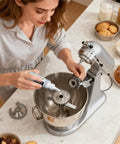 Person applying Pro Grade High Temp Silicone Oil Lubricant For Food Processing Equipment And Conveyors to mixer gears