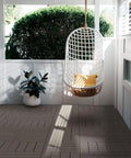 Interlocking Patio Deck Tiles 12x12 Inch Square Composite Plastic Outdoor Flooring in a porch with a hanging chair and plant
