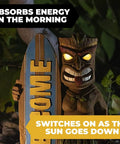 Welcome Tiki Statue With Surfboard Solar Powered 14 Inch Outdoor LED Light Decor with glowing eyes at night in garden.