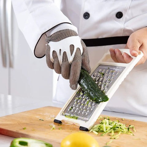 Chainmail Glove Cut Resistant Food Grade Stainless Steel Mesh Safety Glove For Butchers Oyster Shucking Mandoline Slicing Fish Fillet Medium Size Ultra Flexible 304 Stainless Rings For Superior Hand Protection being used for slicing cucumber on a mandoline.