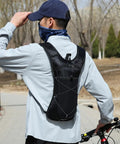 Person wearing Hydration Backpack With Nylon Reservoir And Reflective Strips, Lightweight, Weatherproof Nylon Pack on outdoor trail