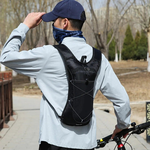 Person wearing Hydration Backpack With Nylon Reservoir And Reflective Strips, Lightweight, Weatherproof Nylon Pack on outdoor trail