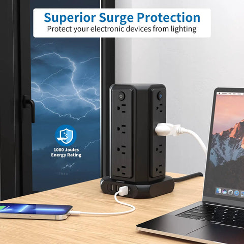 Black Ultimate Surge Protector Power Strip Tower with 16 outlets, 4 USB ports, and 15 ft extension cord on a desk by a window.