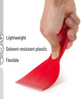 Hand holding a red flexible scraper from the Six Pack Plastic Putty Knife Set With 1.5 To 6 Inch Flexible Solvent Resistant Scrapers