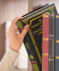Person placing Constitution Book Safe hidden safe in plain sight with combination lock diversion safe for valuables on bookshelf