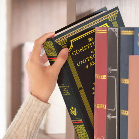 Person placing Constitution Book Safe hidden safe in plain sight with combination lock diversion safe for valuables on bookshelf