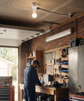 Garage scene with E26 light socket adapter and 3 way power source in use, showing bulb and two outlets, attached to ceiling.