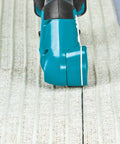 Badass Compact 12V Max Lithium Ion Cordless Multi Cutter cutting textured flooring material with precision.