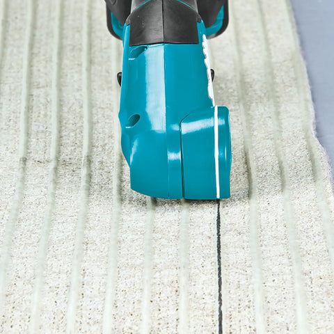 Badass Compact 12V Max Lithium Ion Cordless Multi Cutter cutting textured flooring material with precision.