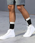 Fresh Black And White Piano Grid Print Crew Socks For Men And Women Straight Up Comfy Polyester Athletic Hosiery worn with white sneakers.