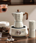 Stovetop Espresso Maker With Double Valve Tech Italian Moka Pot brewing coffee on an electric stove with two mugs.