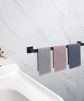 33 Inch Matte Black Stainless Steel Towel Bar Wall Mount Rack For Bathroom with hanging towels, mounted on a white wall.