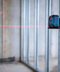 GLL50-20 50 Ft Self Leveling Cross Line Laser With Integrated Magnetic Mount And Battery Flexibility For Quick No Hassle Setup On Any Jobsite Weather Tough IP55 Rated showing red laser on a construction site