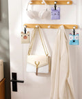 Glasses cleaning cloths 6-pack on wall display with wooden hooks, white headphones, pastel animal pouches.